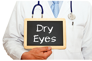 Doctor holding chalkboard that reads "dry eyes"